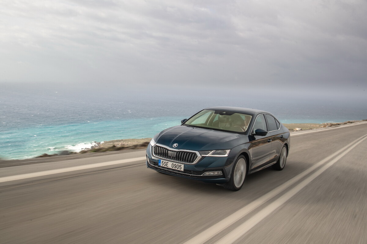 four cars in front of a rocky coast